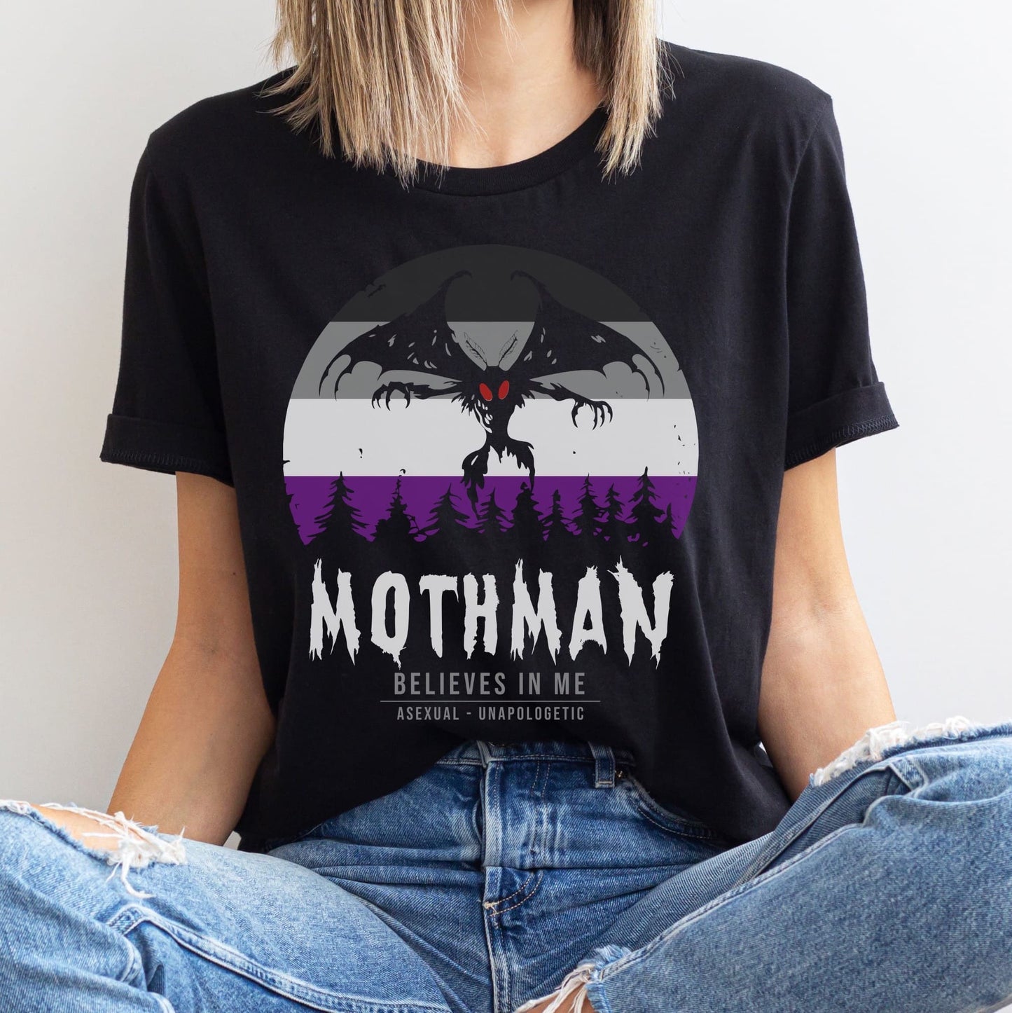 Person wearing a black t-shirt with Mothman graphic and text: Asexual Mothman Shirt, Ace Pride Cryptid Folklore Tee, Queer Mythology Legend Cryptozoology Tshirt, Cryptidcore Weirdcore Gift For LGBT
