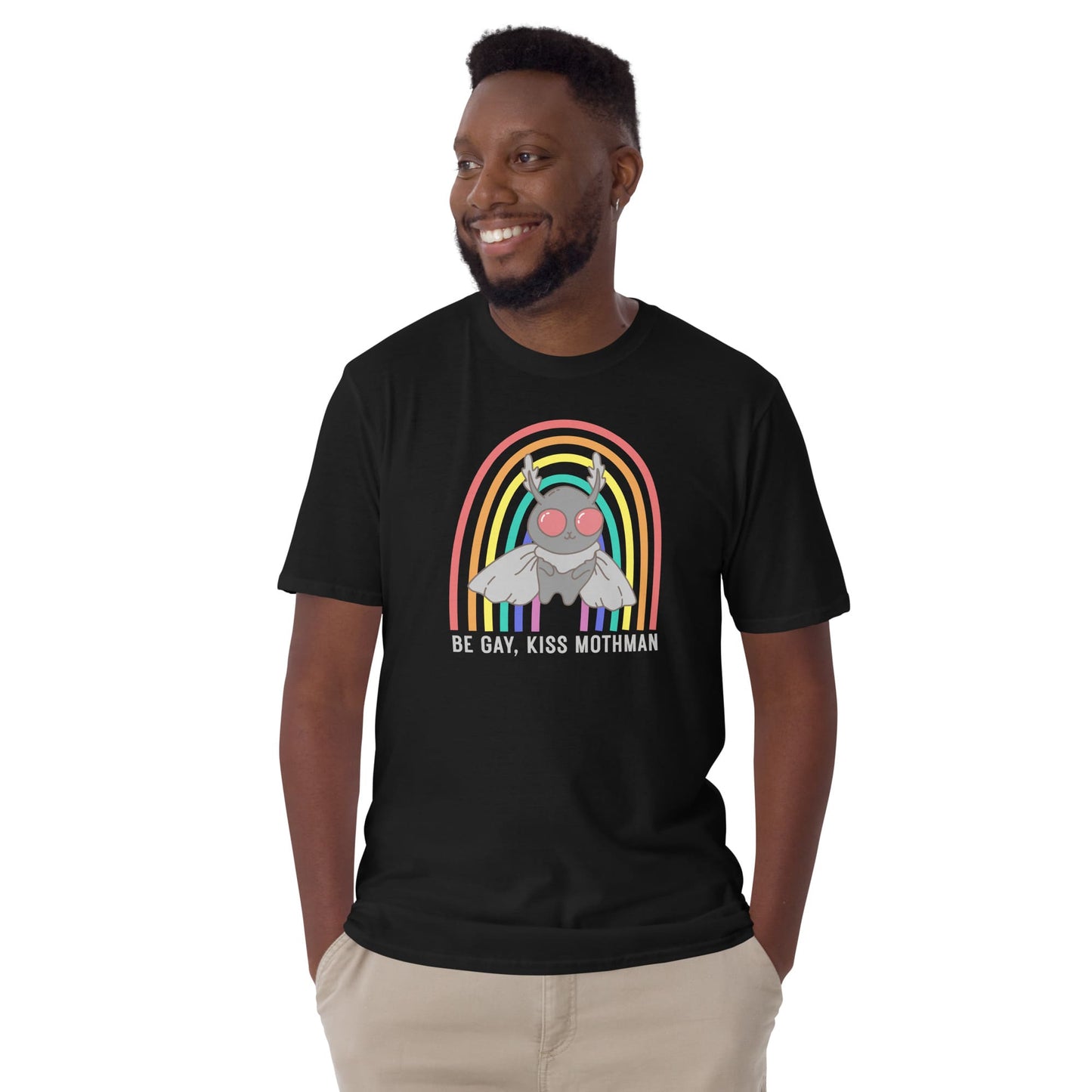 Man wearing a black t-shirt with a graphic design of Mothman and a rainbow, text 'Be Gay, Kiss Mothman' on a white background: LGBTQ Mothman Comfort Colors Shirt, Be Gay Kiss Mothman Tee, Queer Cryptid T-Shirt, LGBT Cryptidcore Gift, Rainbow Cryptozoology Merch