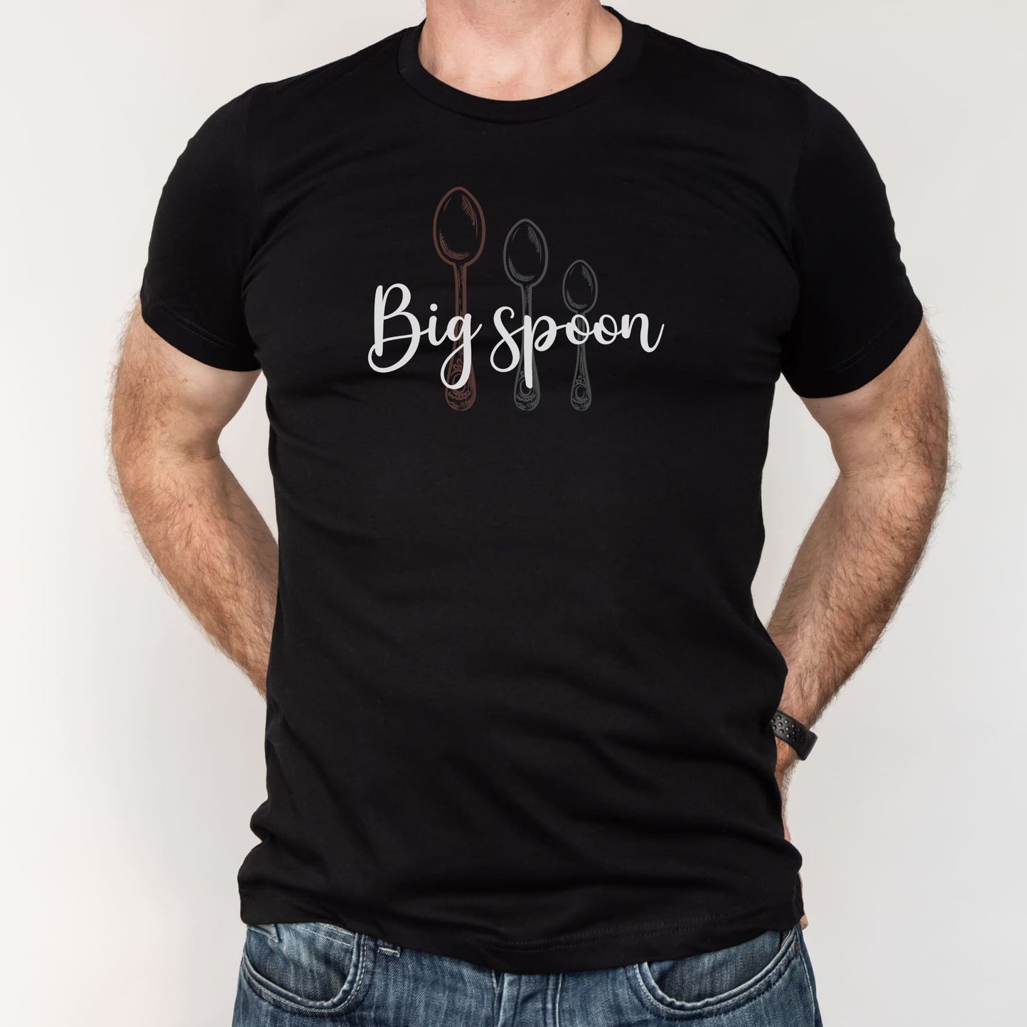 Black t-shirt with 'Big spoon' text and spoon graphics worn by a ENM polyamory person on a white background