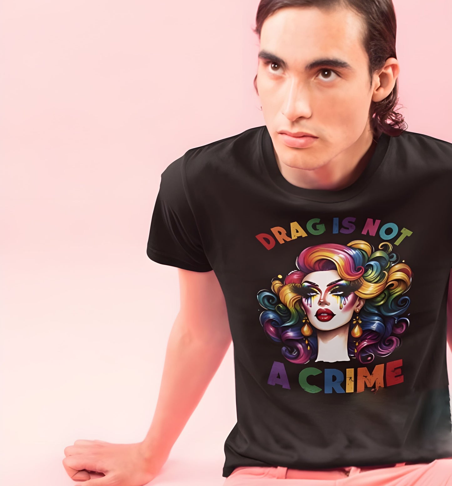 Person wearing a black t-shirt with a colorful graphic and text 'DRAG IS NOT A CRIME' on a pink background: Drag Is Not a Crime Shirt, Drag Queen Pride Tee, Protect Drag Tshirt, Pro Drag Statement Top LGBTQ Gay Pride Month Inclusivity Equality Gift