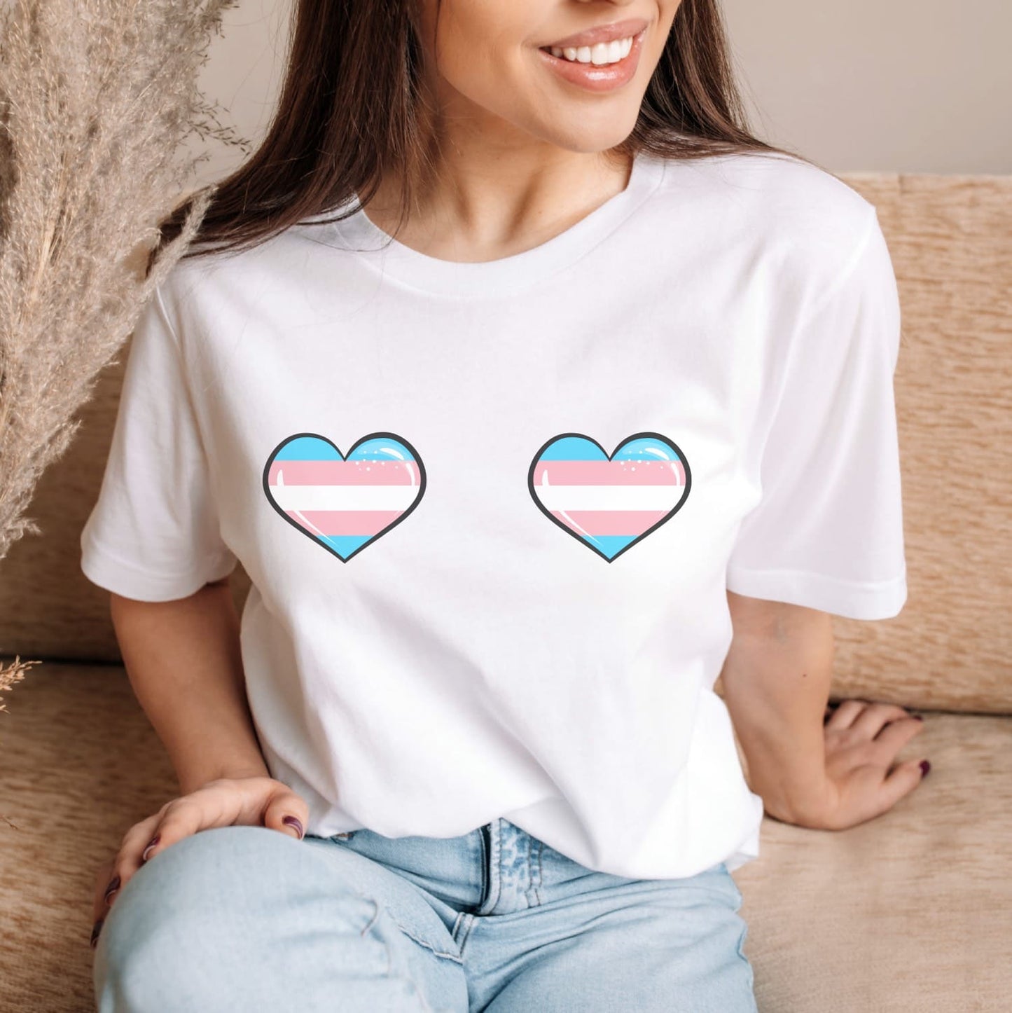 mtf Person wearing a cheeky white t-shirt with two trans hearts as boobs
