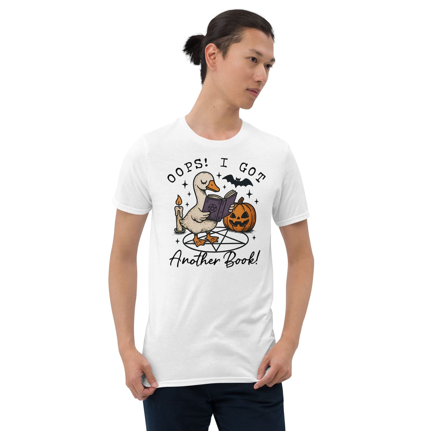 Person wearing a white t-shirt with a graphic design of a goose reading a book, surrounded by Halloween elements: Funny Bookish Goose Shirt, Spooky Season Book Tee, Fall Library T-Shirt, Reading Gift For Halloween Lover Cute Trick Or Treat Teacher Outfit