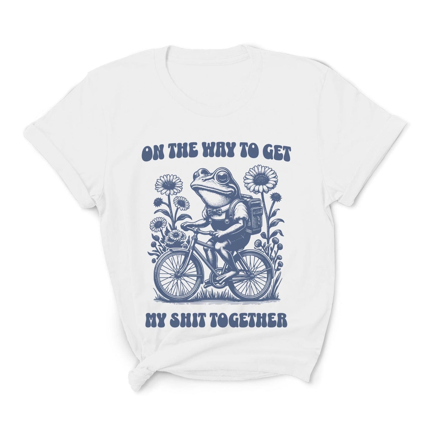 White t-shirt with a graphic of a frog riding a bike and text on a white background: Funny Neurodivergent Shirt, ADHD AuDHD Tee, Mental Health T-Shirt, Vintage Frog, Sarcastic Adult Humor, On The Way To Get My Shit Together