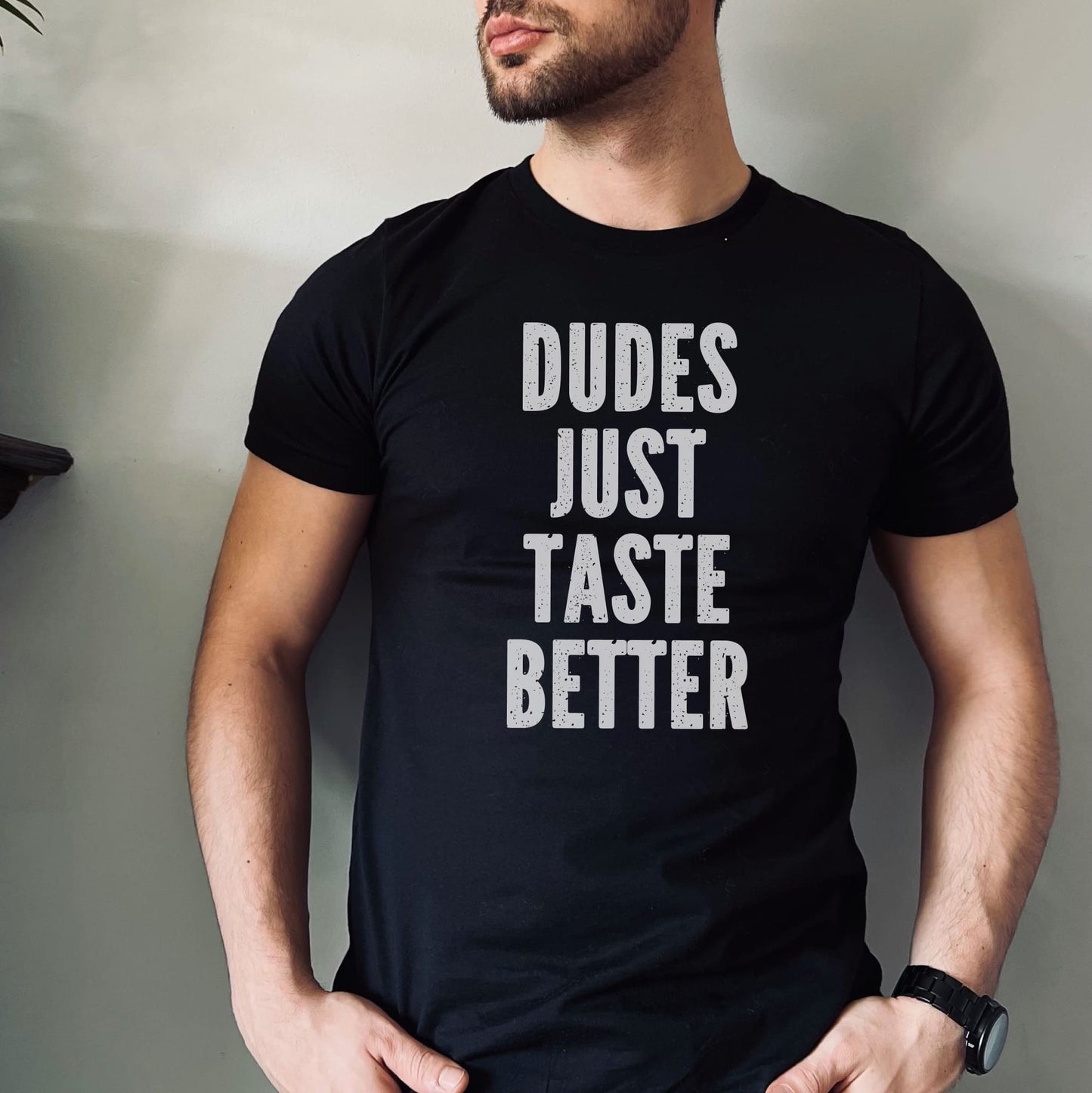 Person wearing a black t-shirt with 'DUDES JUST TASTE BETTER' text against a neutral background: Funny Gay MLM Shirt, Grindr Male Dating Meme T-Shirt, Bear Pride Tee, LGBTQ Streetwear, Gay Daddy Tshirt, Dudes Just Taste Better