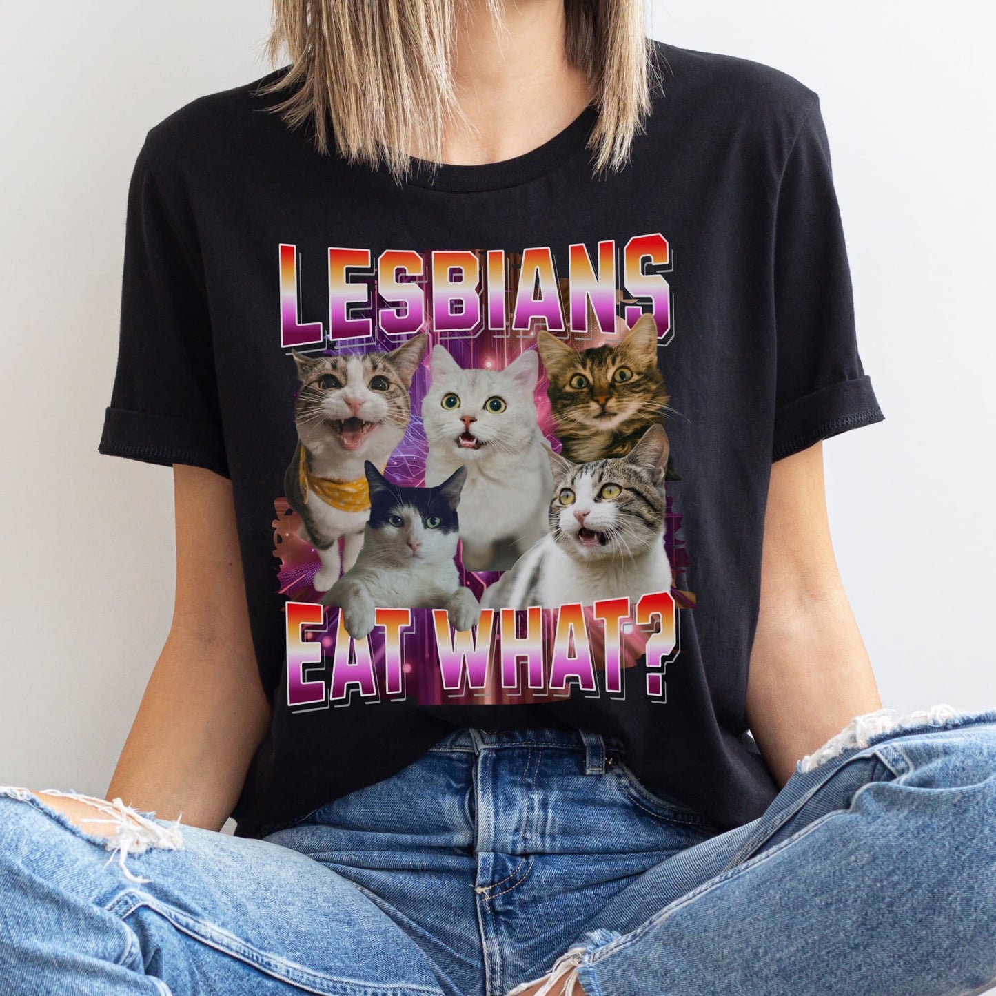 Person wearing a black bootleg y2k t-shirt with cat graphic and text 'LESBIANS EAT WHAT?'