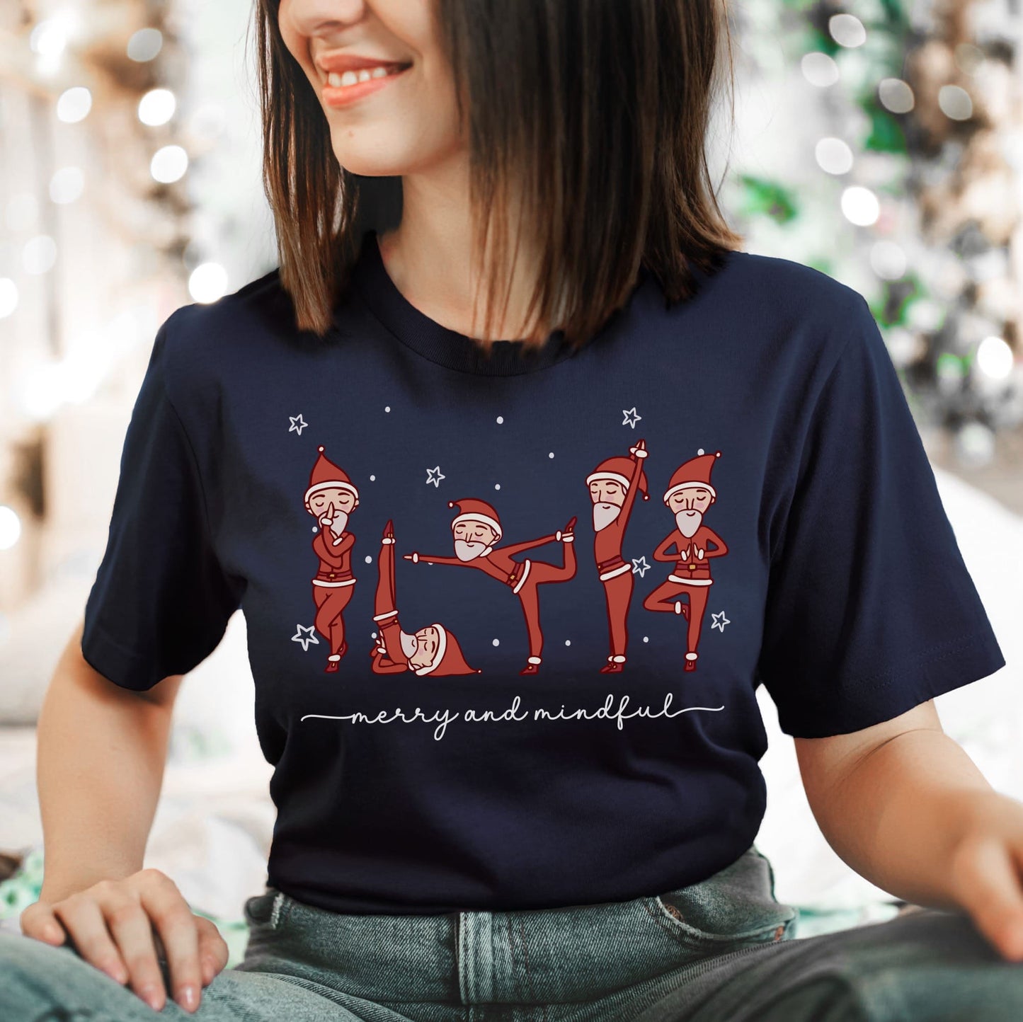 Person wearing a navy blue t-shirt with Christmas-themed design featuring Santa Claus in various yoga poses.
