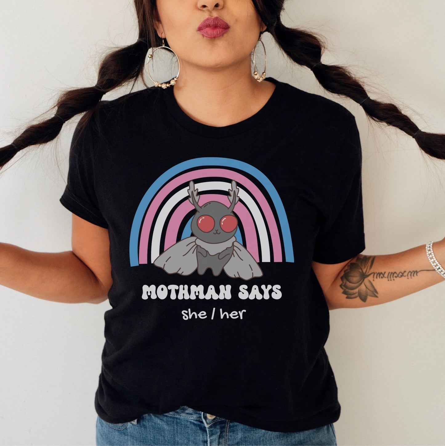 Person wearing a black t-shirt with Mothman graphic and 'Mothman says she/her' text: Personalized Trans Mothman Shirt, Custom Pronouns Transgender Pride Cryptid Tee, Folklore Mythology TShirt, Queer Cryptozoology FTM FTM Gift