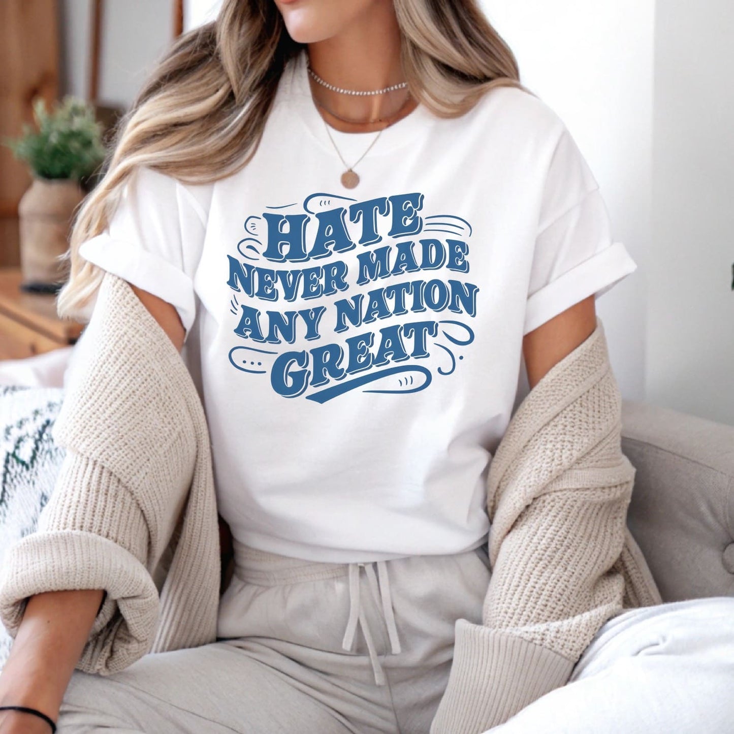 Person wearing a white t-shirt with blue text in a casual setting