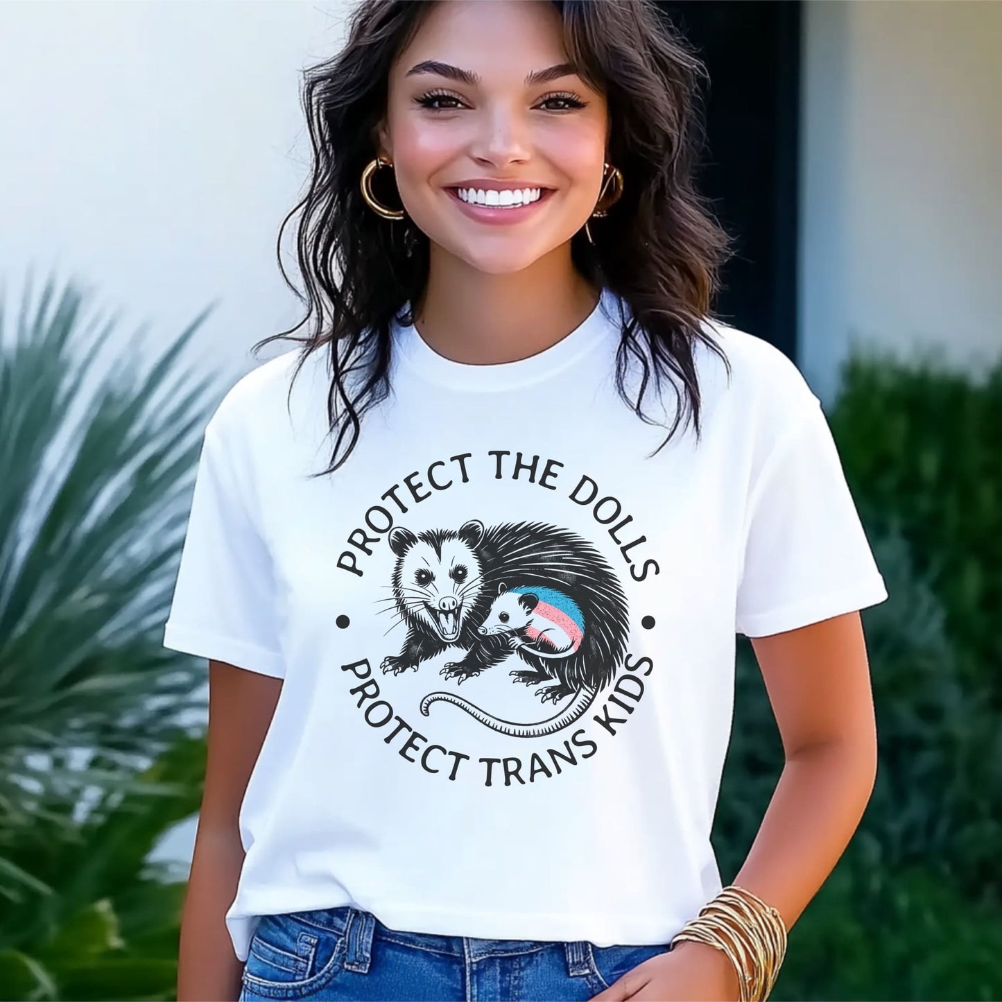 Woman wearing a white t-shirt with a graphic and text, standing outdoors: Protect The Dolls Shirt, Protect Trans Kids Tee, Transgender Pride T-Shirt, Unhinged Opossum Fighting Trans Rights Shirt, MTF Femme Mom Gift