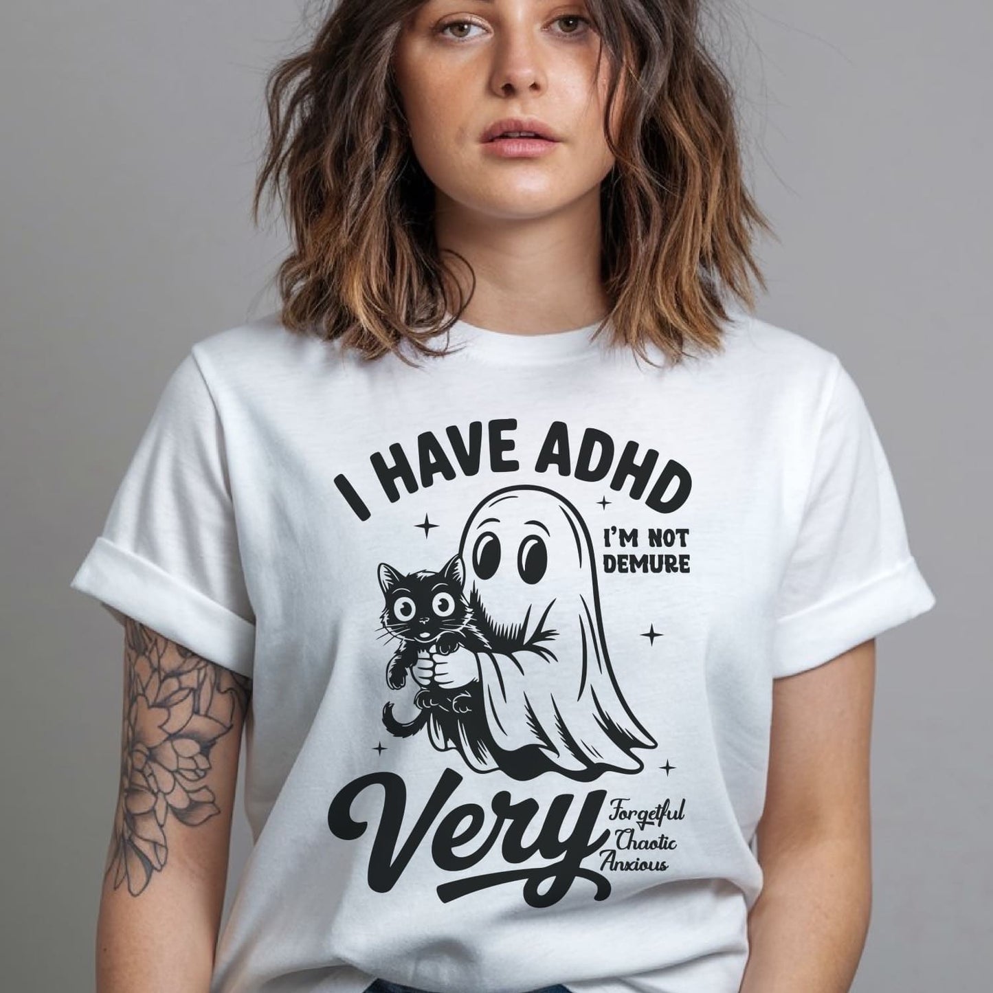 Person wearing a white t-shirt with a graphic design and text: Spooky ADHD Shirt, Funny Neurodiversity Halloween Tee, Neurospicy Gift For AuDHD, Mental Health Awareness Tshirt, Cute Neurodivergent Ghost