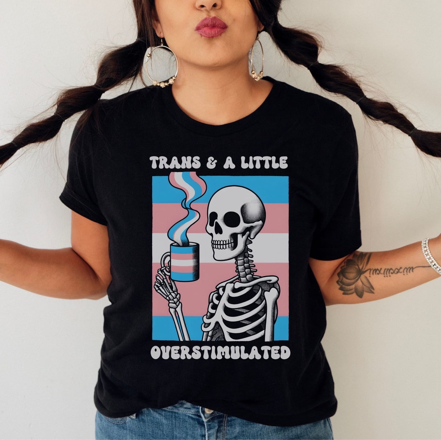 Person wearing a black t-shirt with a skeleton design and text, standing against a plain background: Transgender Anxiety Shirt, Overstimulated Tee, Mental Health T-Shirt, Trans Pride Skeleton Shirt, Sarcastic Neurospicy Gift For MTF Or FTM