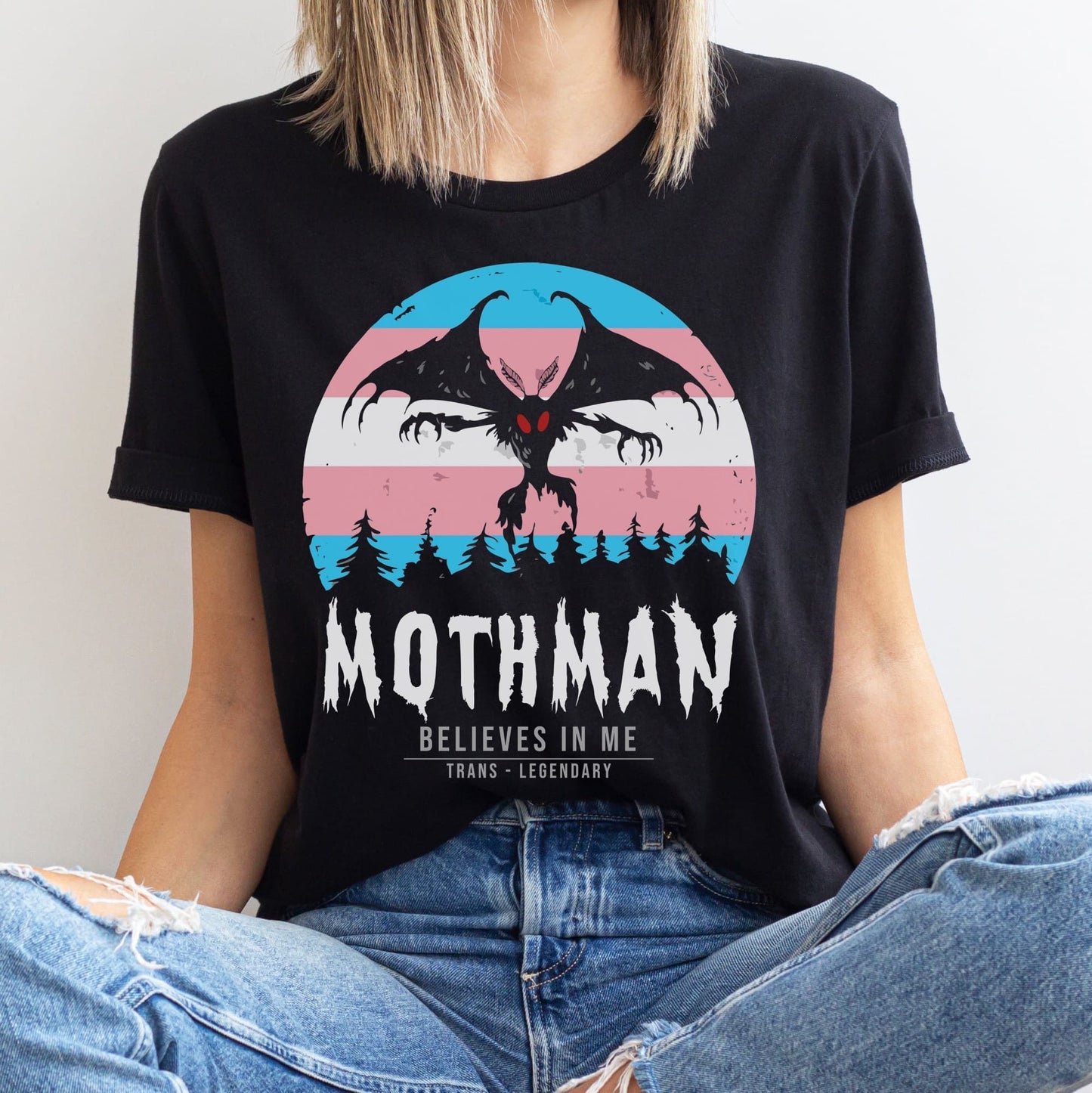 Person wearing a black t-shirt with Mothman graphic and text: Transgender Mothman Shirt, Trans Pride Cryptid Folklore Tee, Queer Mythology Legend Cryptozoology T-Shirt, Cryptidcore Weirdcore LGBT Gift