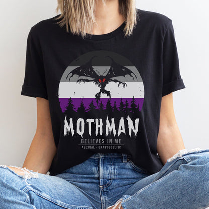 Person wearing a black t-shirt with Mothman graphic and text: Asexual Mothman Shirt, Ace Pride Cryptid Folklore Tee, Queer Mythology Legend Cryptozoology Tshirt, Cryptidcore Weirdcore Gift For LGBT