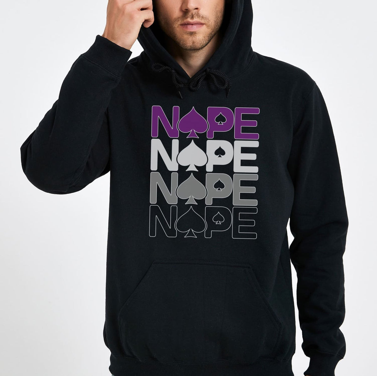 Person wearing a black asexual ace of spades hoodie with 'NOPE' text and spade symbol on a white background