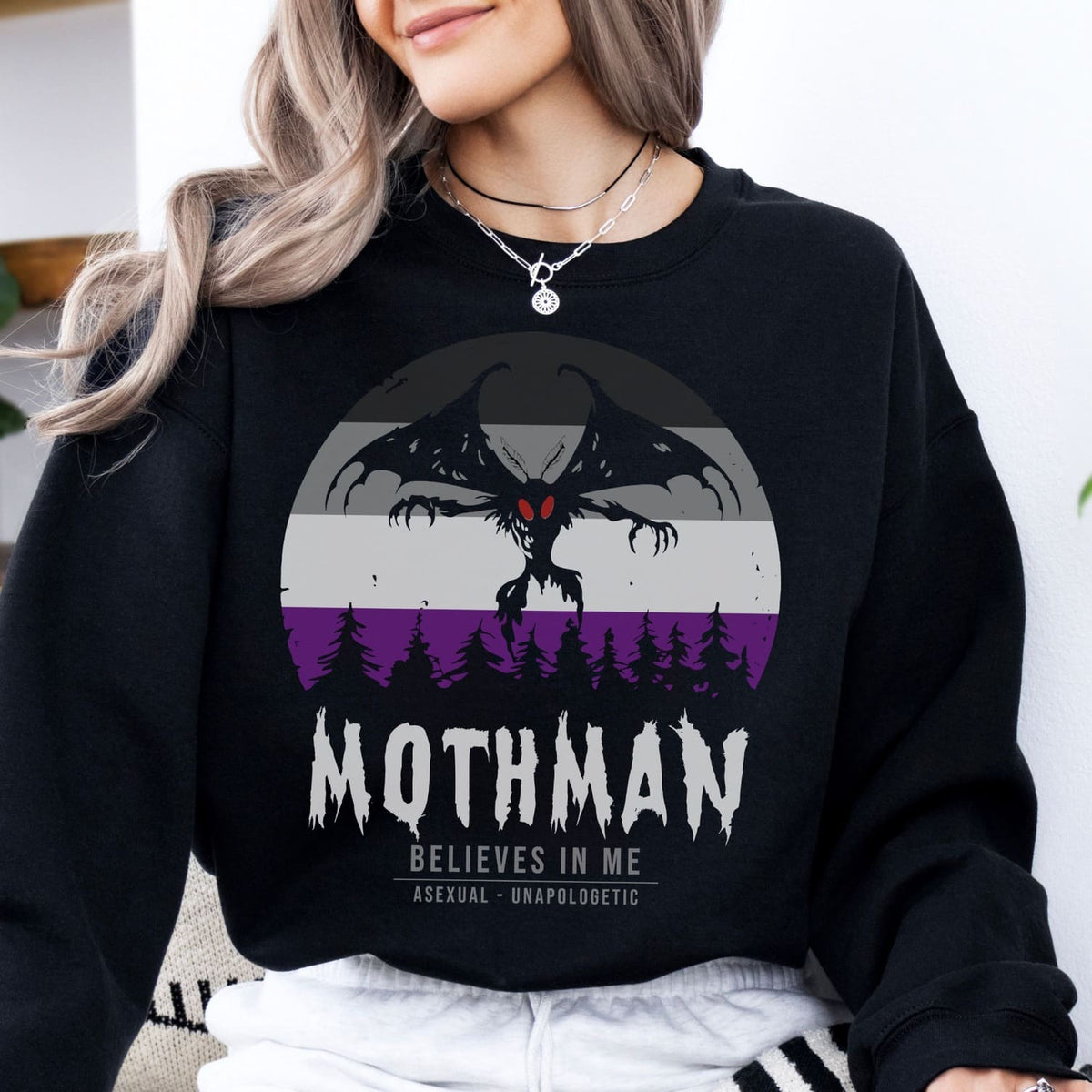 Person wearing a black asexual sweatshirt with Mothman graphic and text