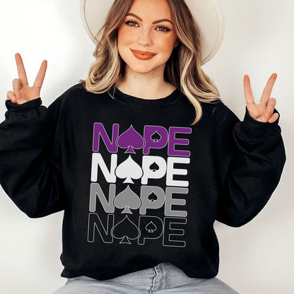 Person wearing a black asexual ace of spades sweatshirt with 'NOPE' text and peace signs.