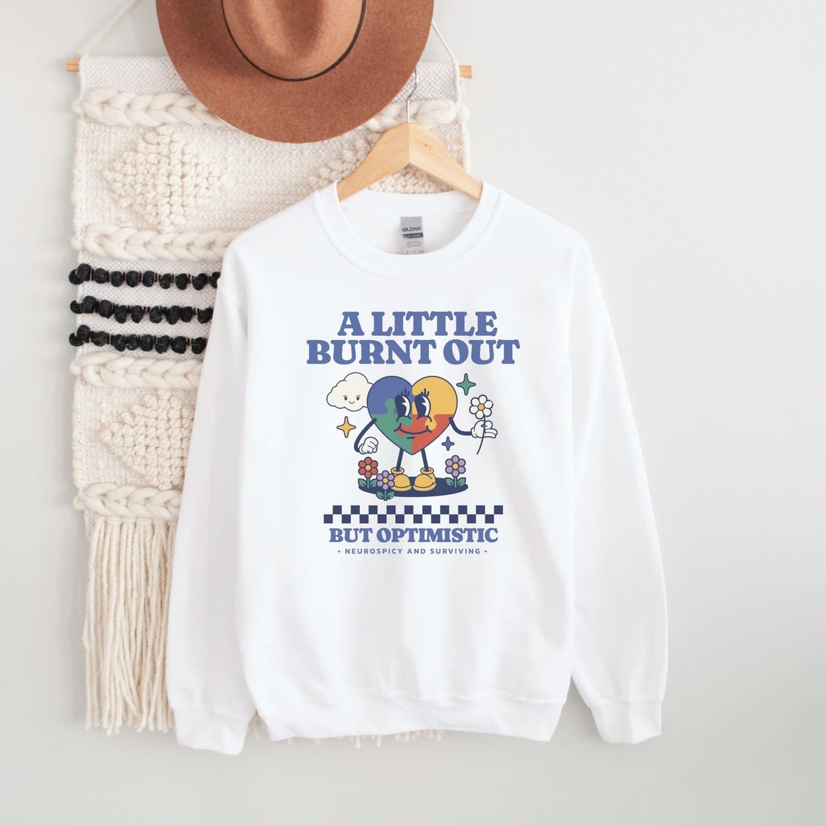 White neurodivergent sweatshirt with cartoon design and text on a white background