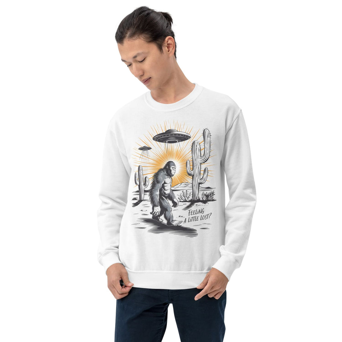 Person wearing a white sweatshirt with a graphic design of bigfoot, cactus, and UFO.