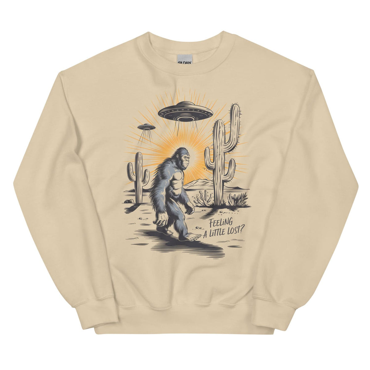 Beige sweatshirt with a graphic of a Sasquatch, UFO, and cactus on a white background