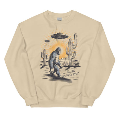 Beige sweatshirt with a graphic of a Sasquatch, UFO, and cactus on a white background