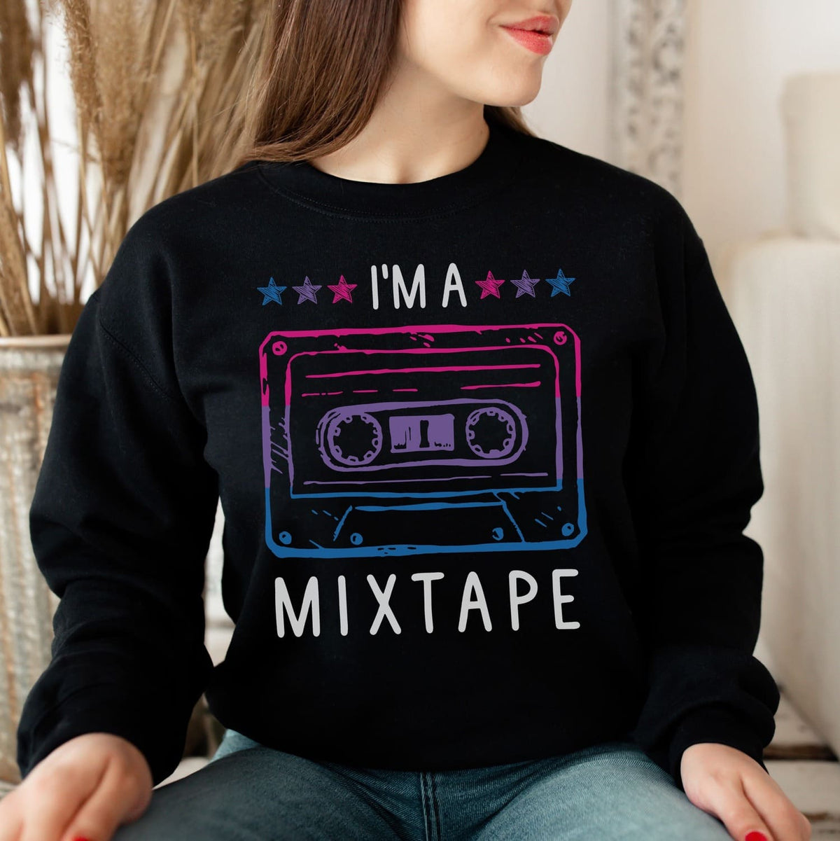 Person wearing a black bisexual sweatshirt with a colorful cassette tape graphic and 'I'm a Mixtape' text.