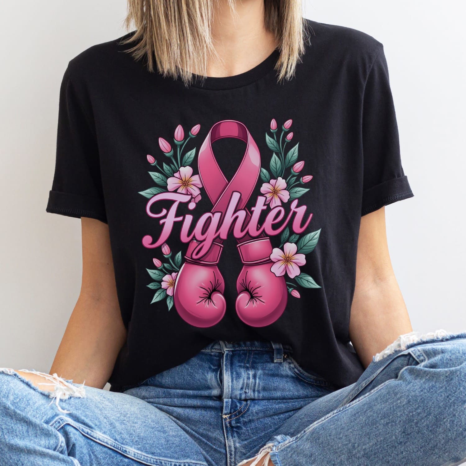Person wearing a black t-shirt with pink boxing gloves, pink ribbon, and flowers on a white background