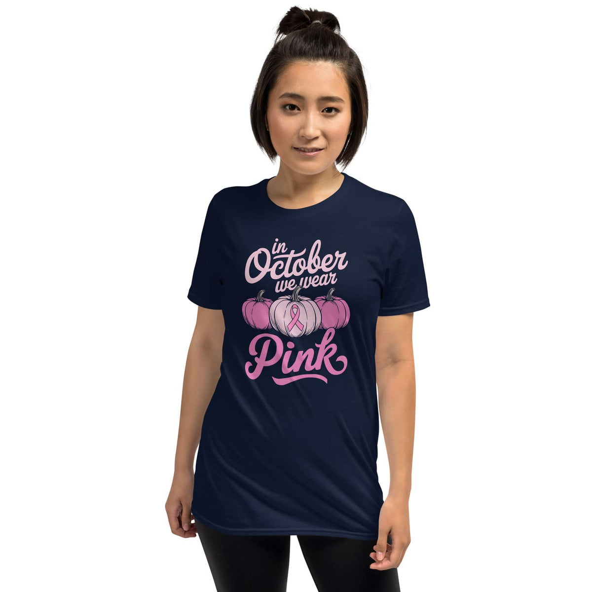 Woman wearing a navy blue t-shirt with 'In October we wear Pink' text and breast cancer awareness design.