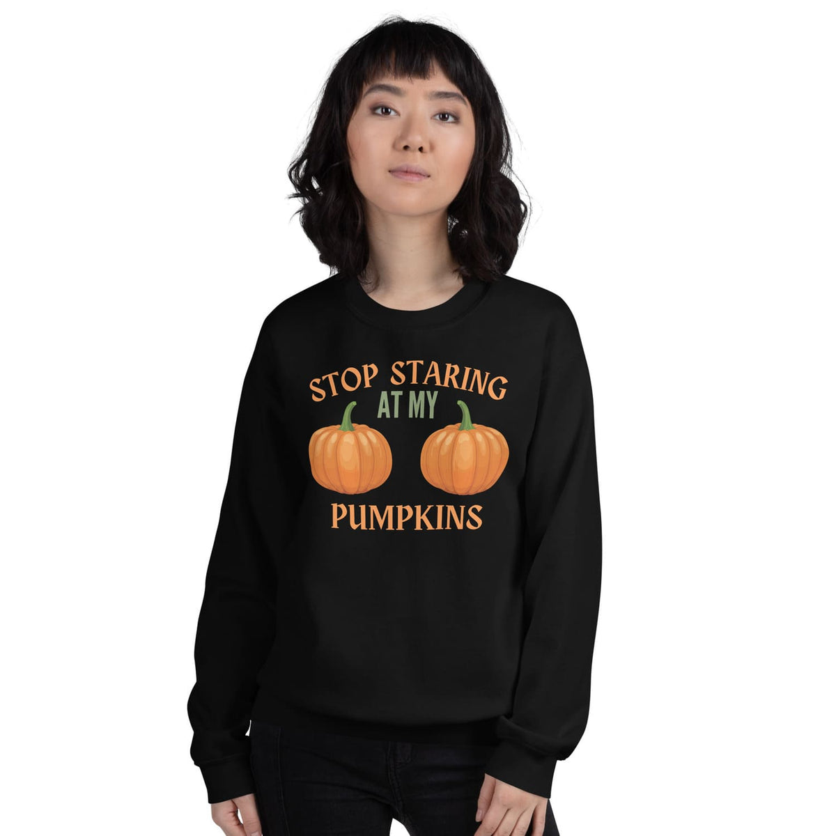 Person wearing a black halloween sweatshirt with pumpkin boobs design and text on a white background