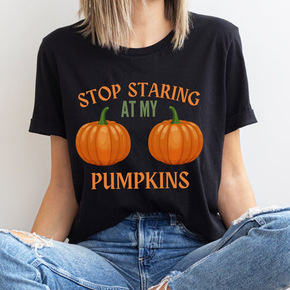 Person wearing a black halloween t-shirt with pumpkin boobs design and text.