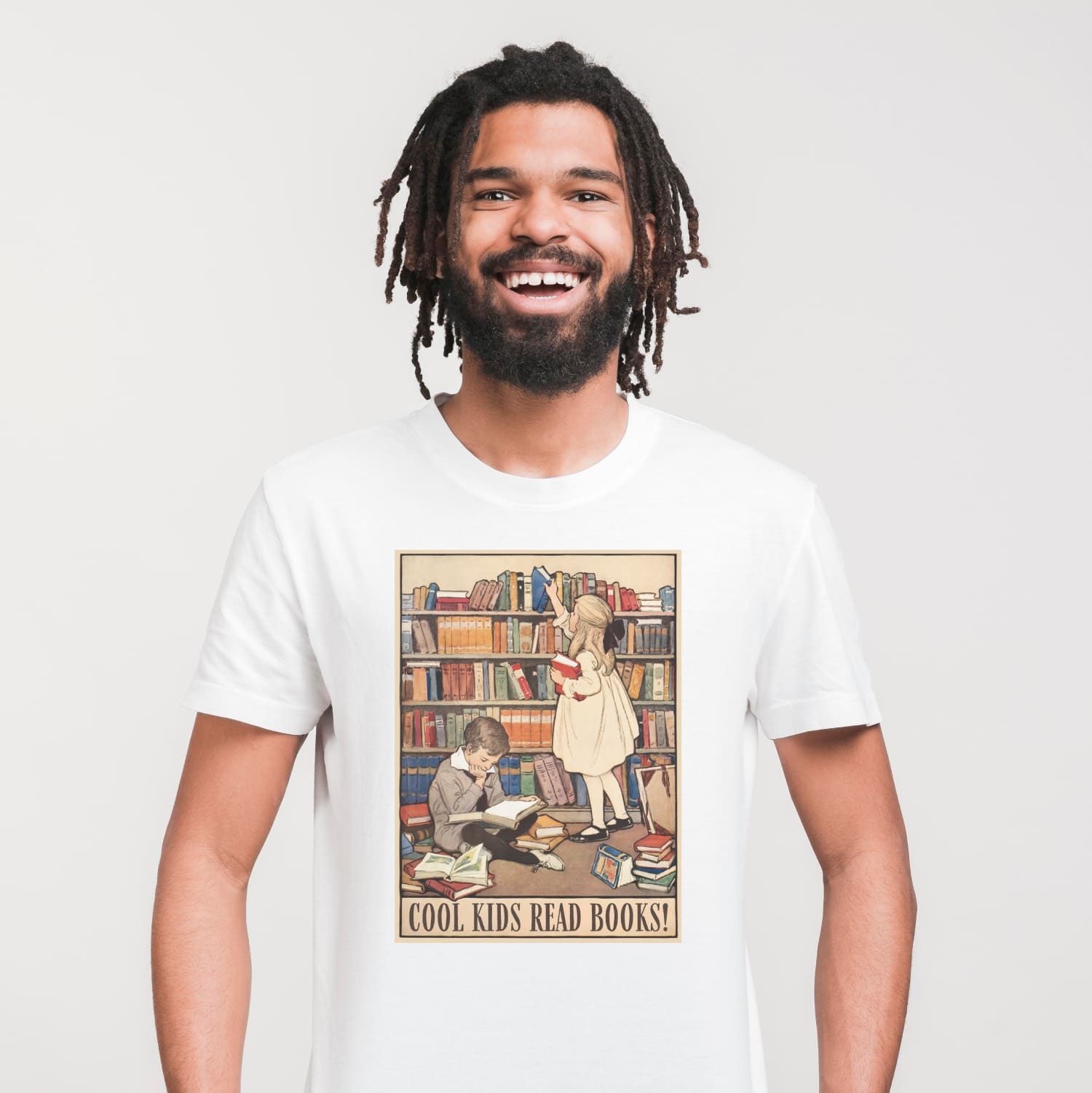 Person wearing a white t-shirt with a graphic of children in a library and 'Cool Kids Read Books!' text.
