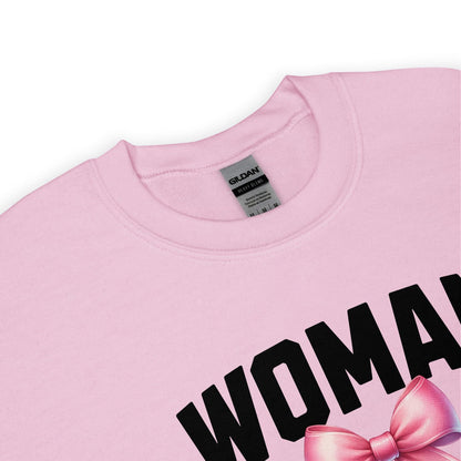 Pink mtf transgender sweatshirt with 'WOMAN' and a pink bow on a white background