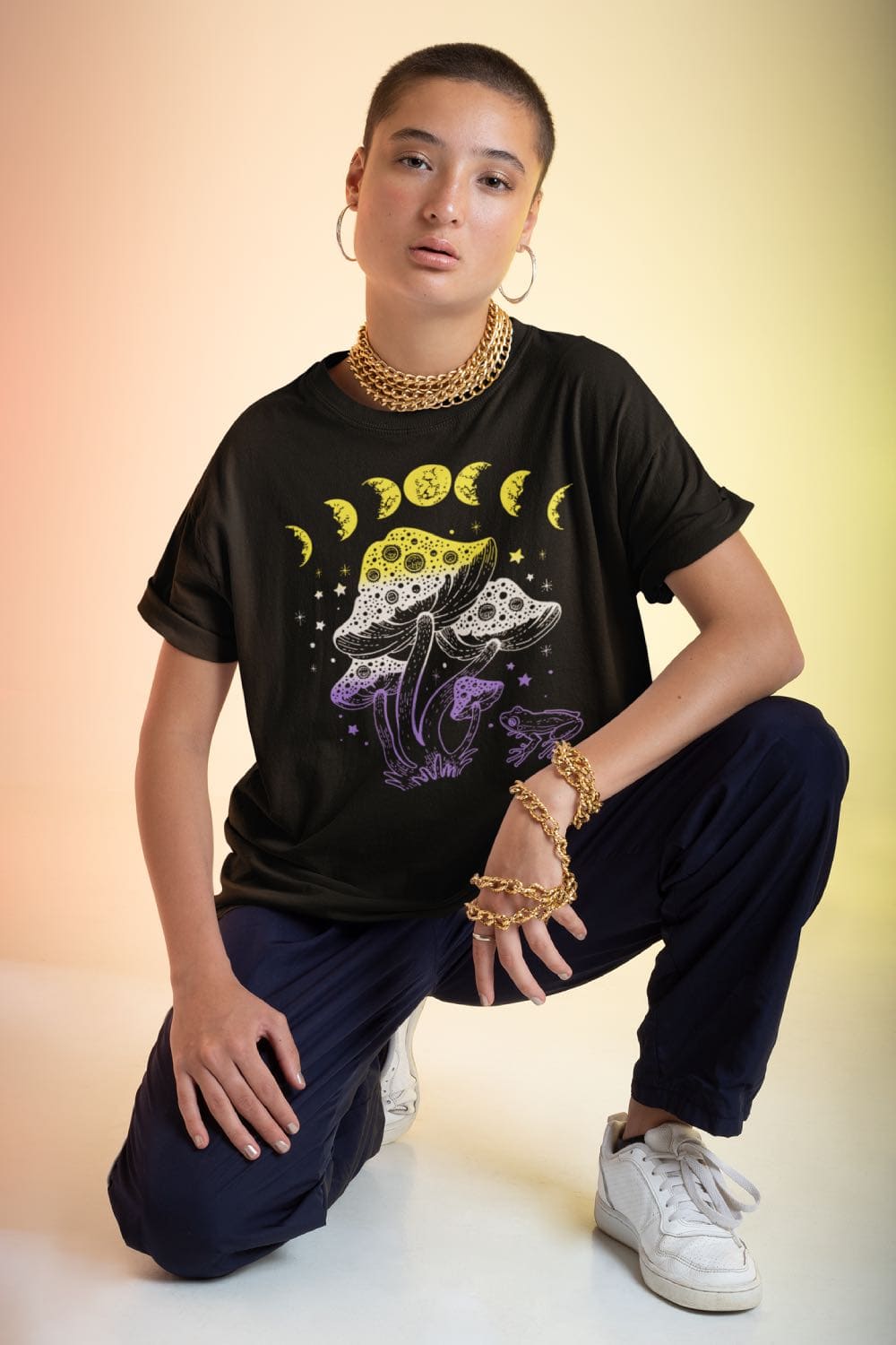 nonbinary shirt, cottagecore design with frog, mushrooms and moon phases, in use