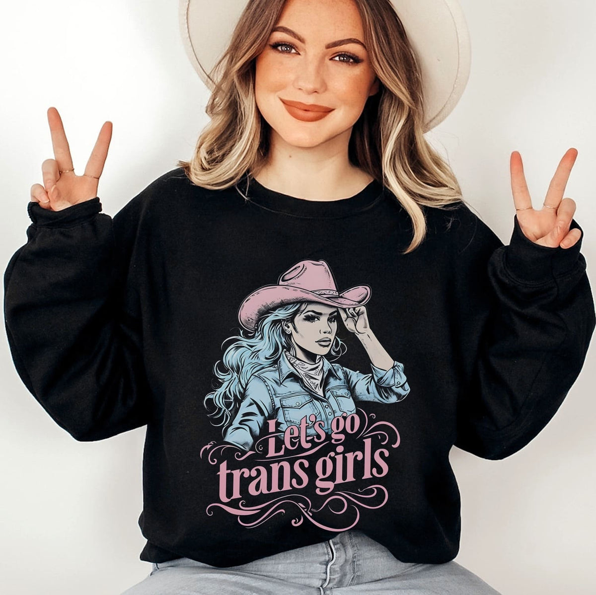 Person wearing a black mtf transgender sweatshirt with a graphic and text, making peace signs.