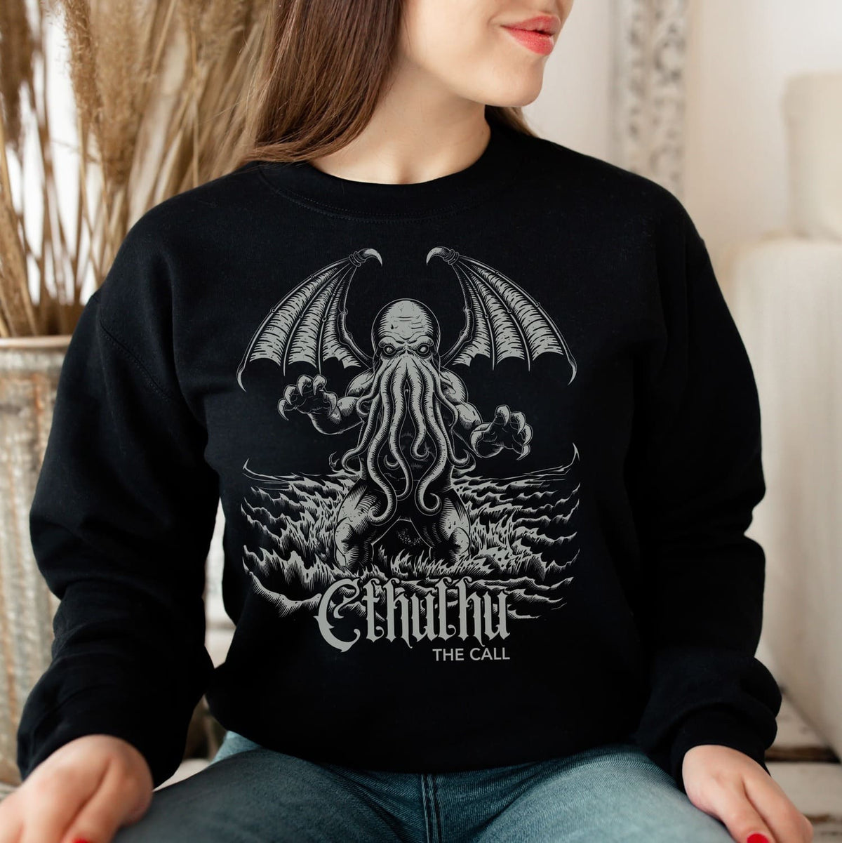 Person wearing a black sweatshirt with Cthulhu design and 'The Call' text.