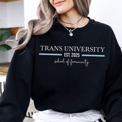 transgender mtf Person wearing a black sweatshirt with 'TRANS UNIVERSITY EST. 2025 school of femininity' text.