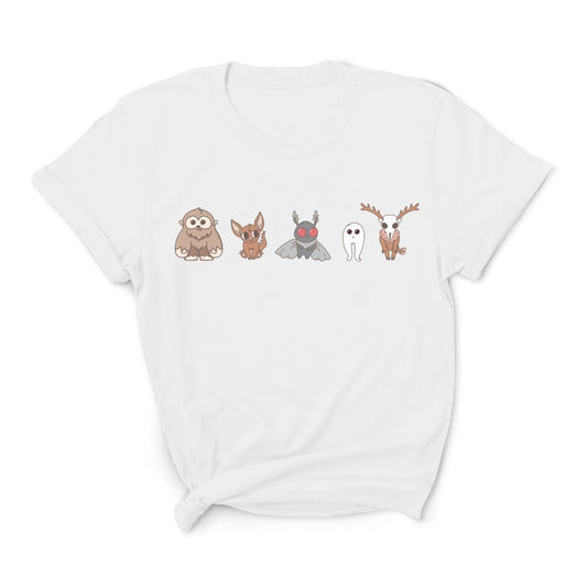 White t-shirt with cartoon character designs on a white background: Cute Cryptids Comfort Colors Shirt, Kawaii Bigfoot Chupacabra Mothman Fresno Wendigo Tee, Funny Cryptidcore Gift, Folklore Mythology T-Shirt