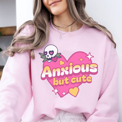 Person wearing a pink sweatshirt with a skull and heart design and text 'Anxious but cute'.