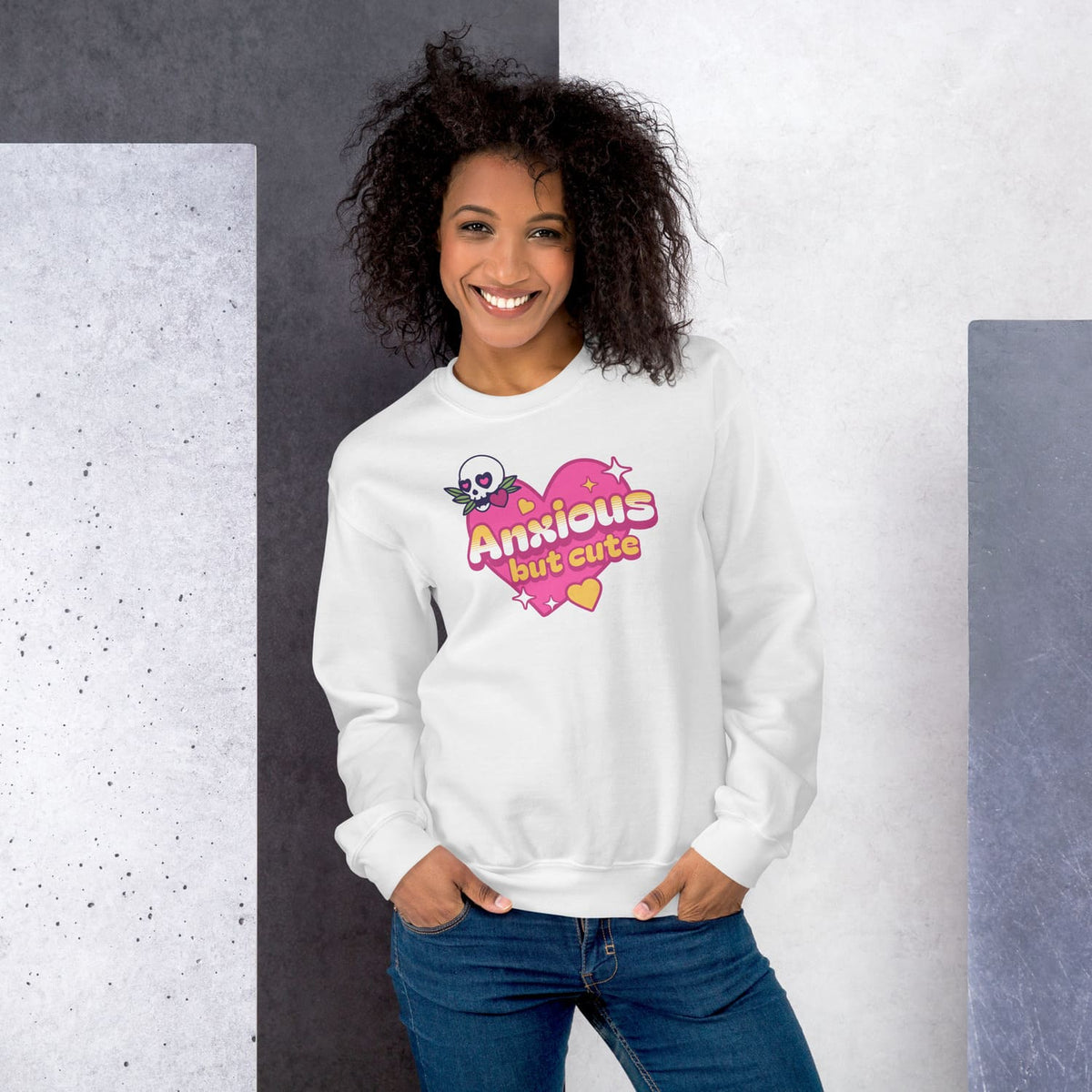 Woman wearing a white sweatshirt with 'Anxious but cute' design against a gray and white background