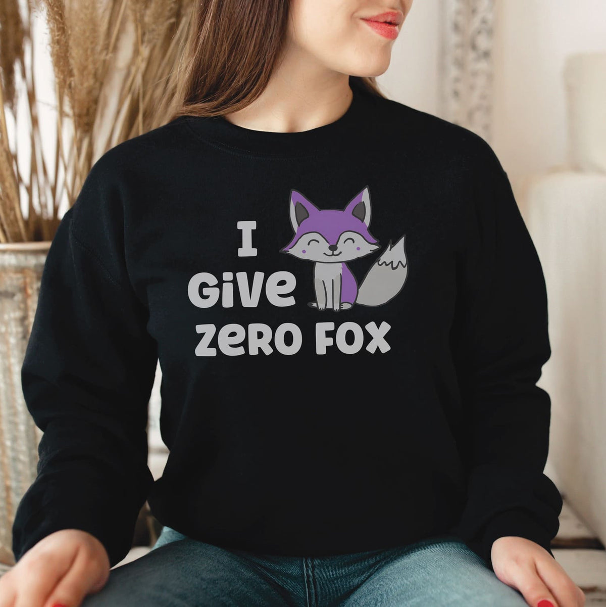 Person wearing a black asexual sweatshirt with a fox graphic and text indoors.