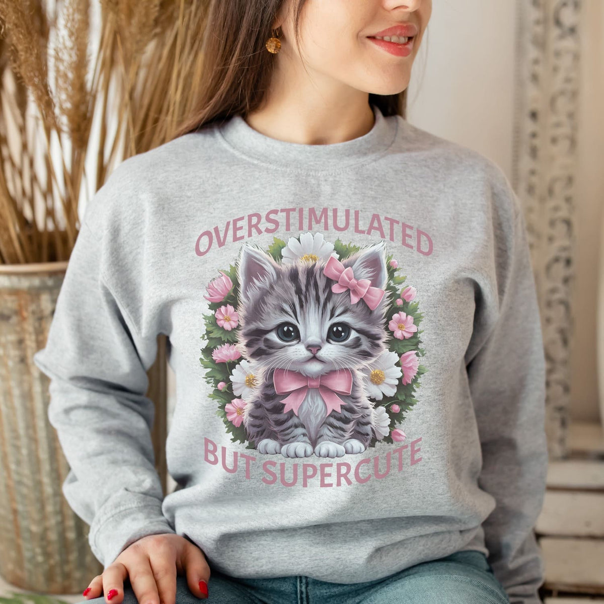 Person wearing a gray neurospicy sweatshirt with a kitten graphic and text