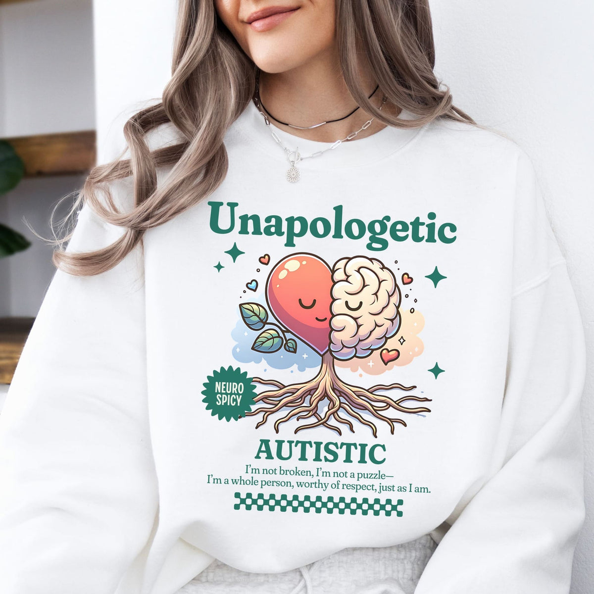 Person wearing a white sweatshirt with a colorful design and text about autism.