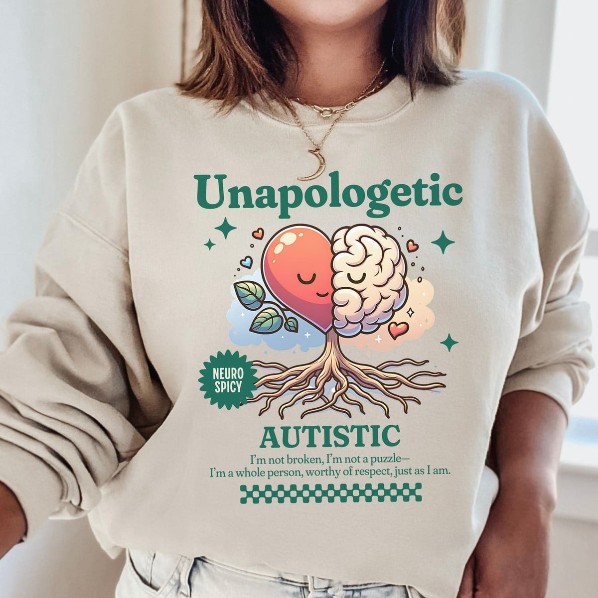 Person wearing a beige sweatshirt with a colorful graphic and text about autism.