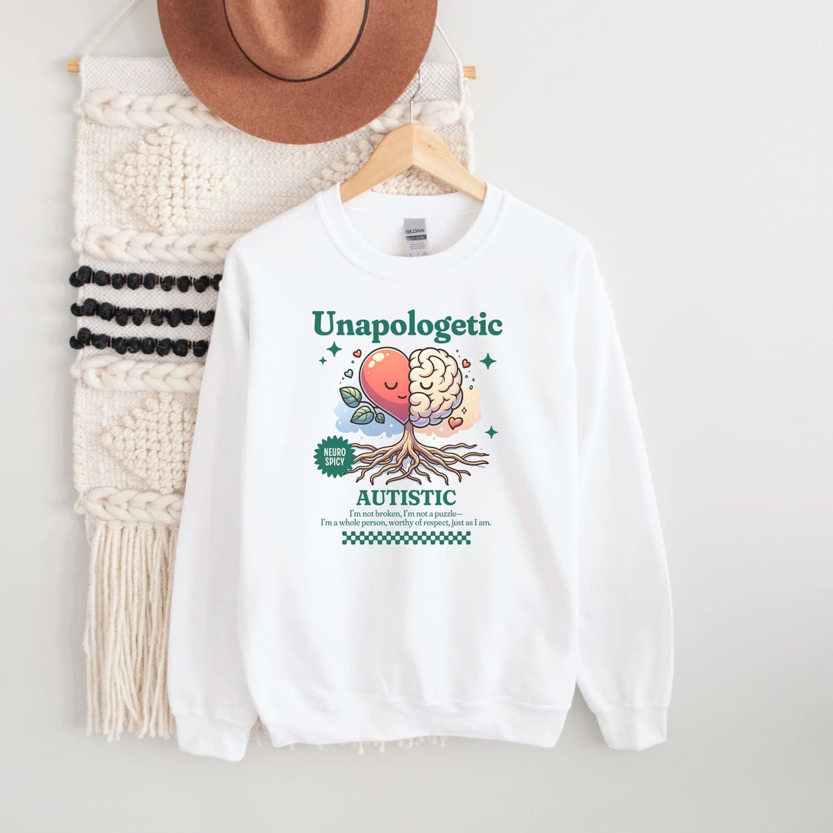 White sweatshirt with 'Unapologetic Autistic' graphic design on a white background