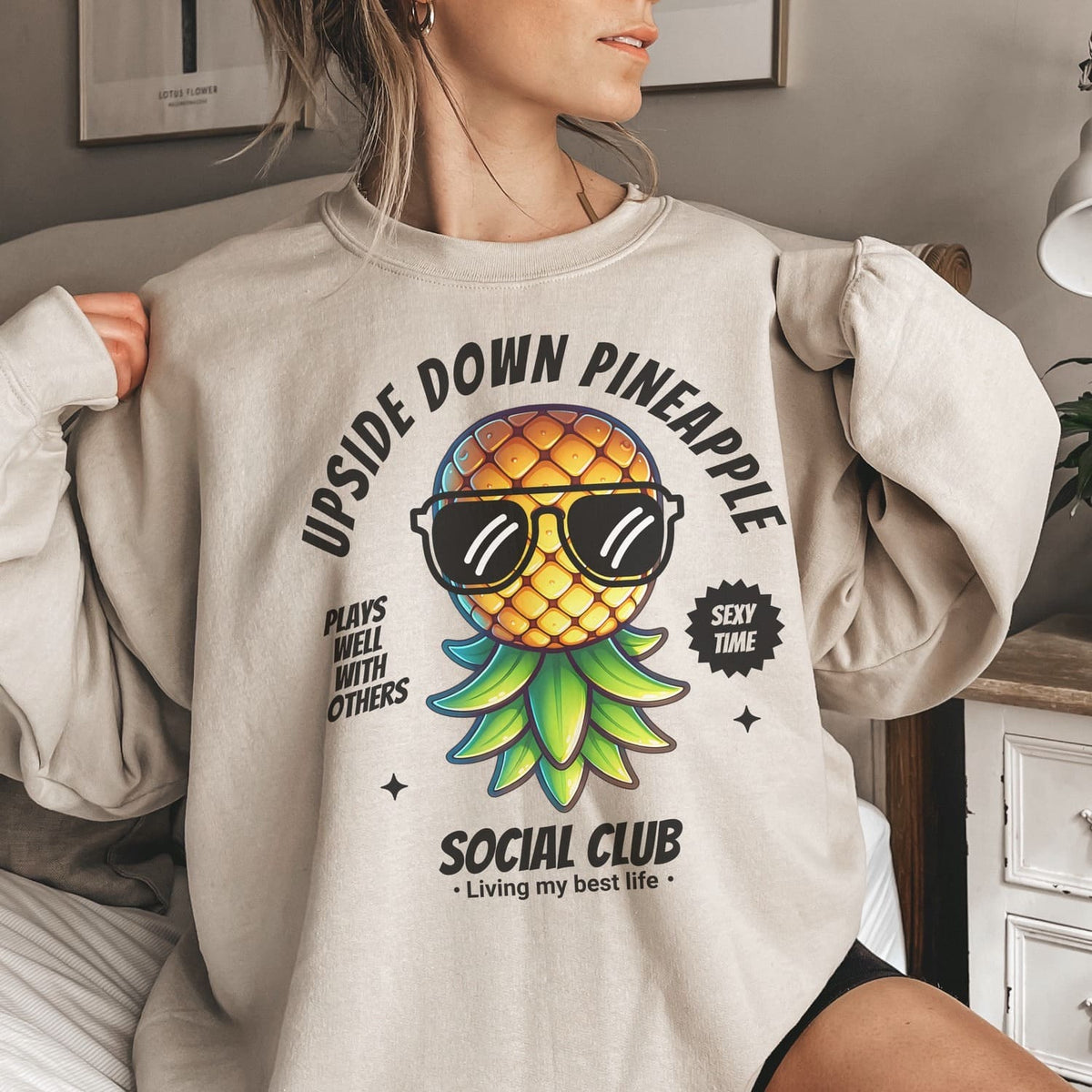Person wearing a swisweatshirt with an upside down pineapple graphic and text.gers 