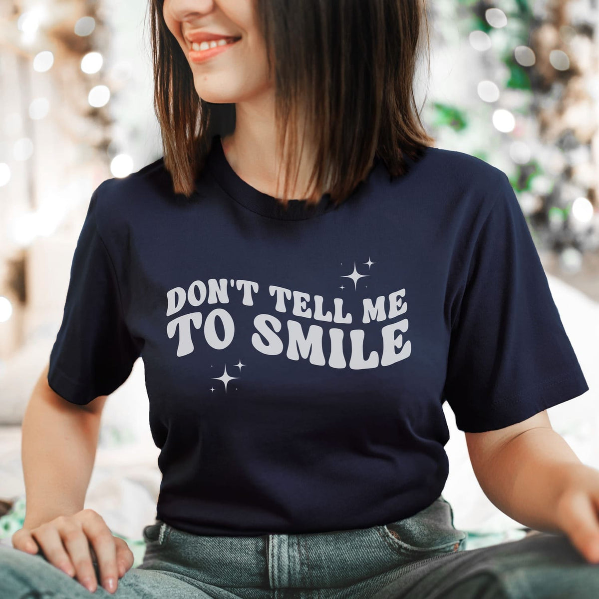Person wearing a navy blue feminist t-shirt with 'DON'T TELL ME TO SMILE' text.
