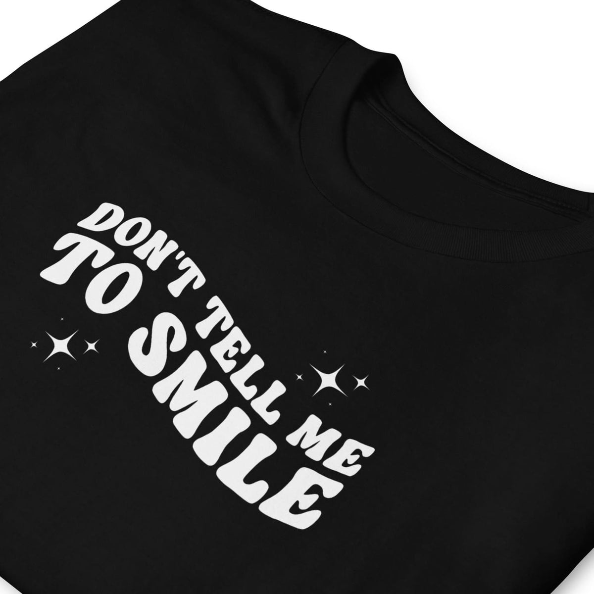 Black feminist t-shirt with white text 'Don't Tell Me To Smile' on a white background