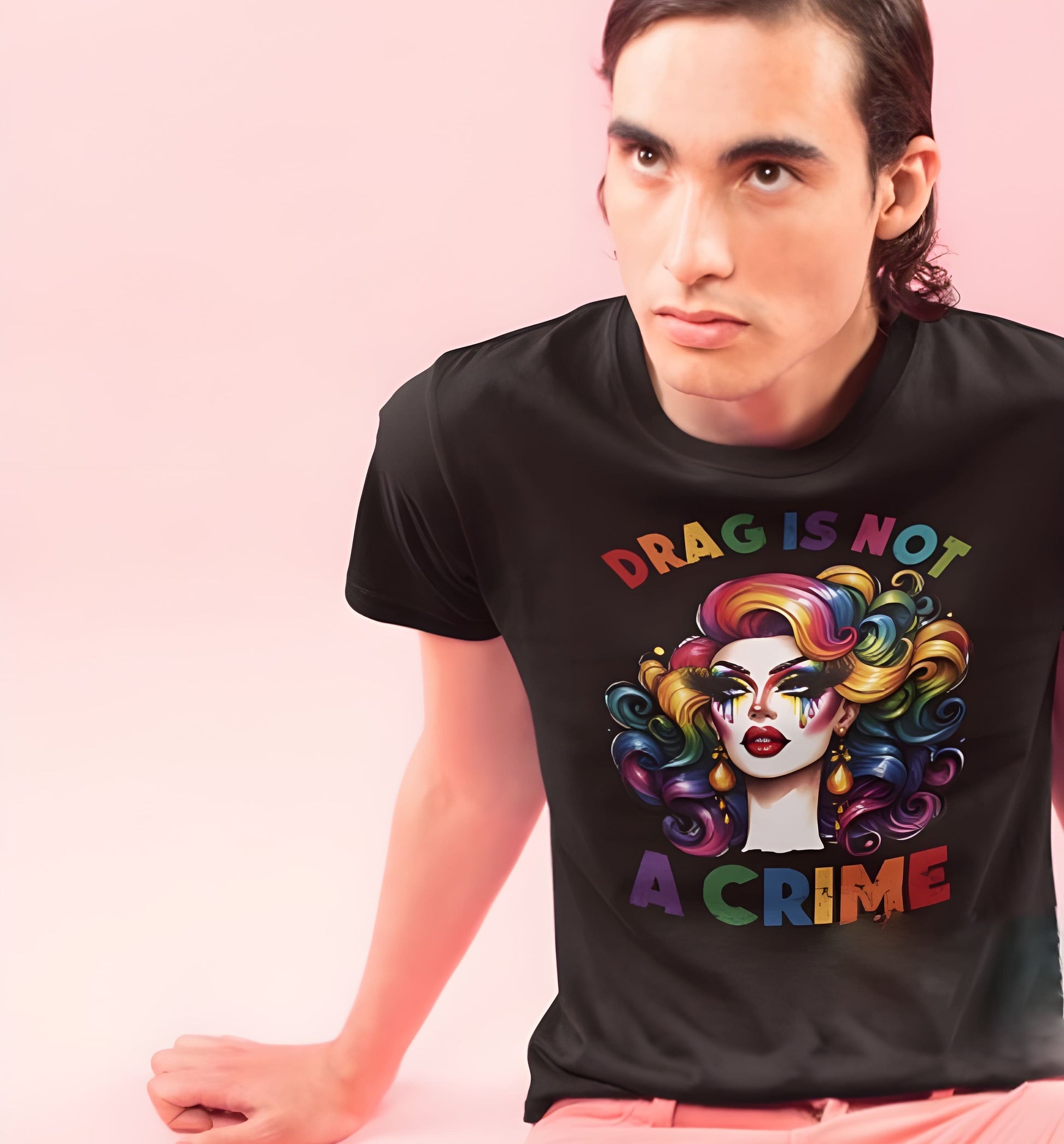 Person wearing a black t-shirt with a colorful graphic and text 'DRAG IS NOT A CRIME' on a pink background: Drag Is Not a Crime Shirt, Drag Queen Pride Tee, Protect Drag Tshirt, Pro Drag Statement Top LGBTQ Gay Pride Month Inclusivity Equality Gift