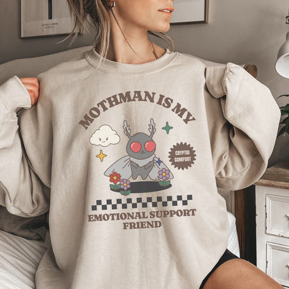 Person wearing a beige mental health  sweatshirt with a graphic design of Mothman and text.