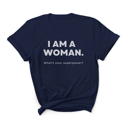 Navy blue feminist t-shirt with white text 'I AM A WOMAN. What's your superpower?' on a white background