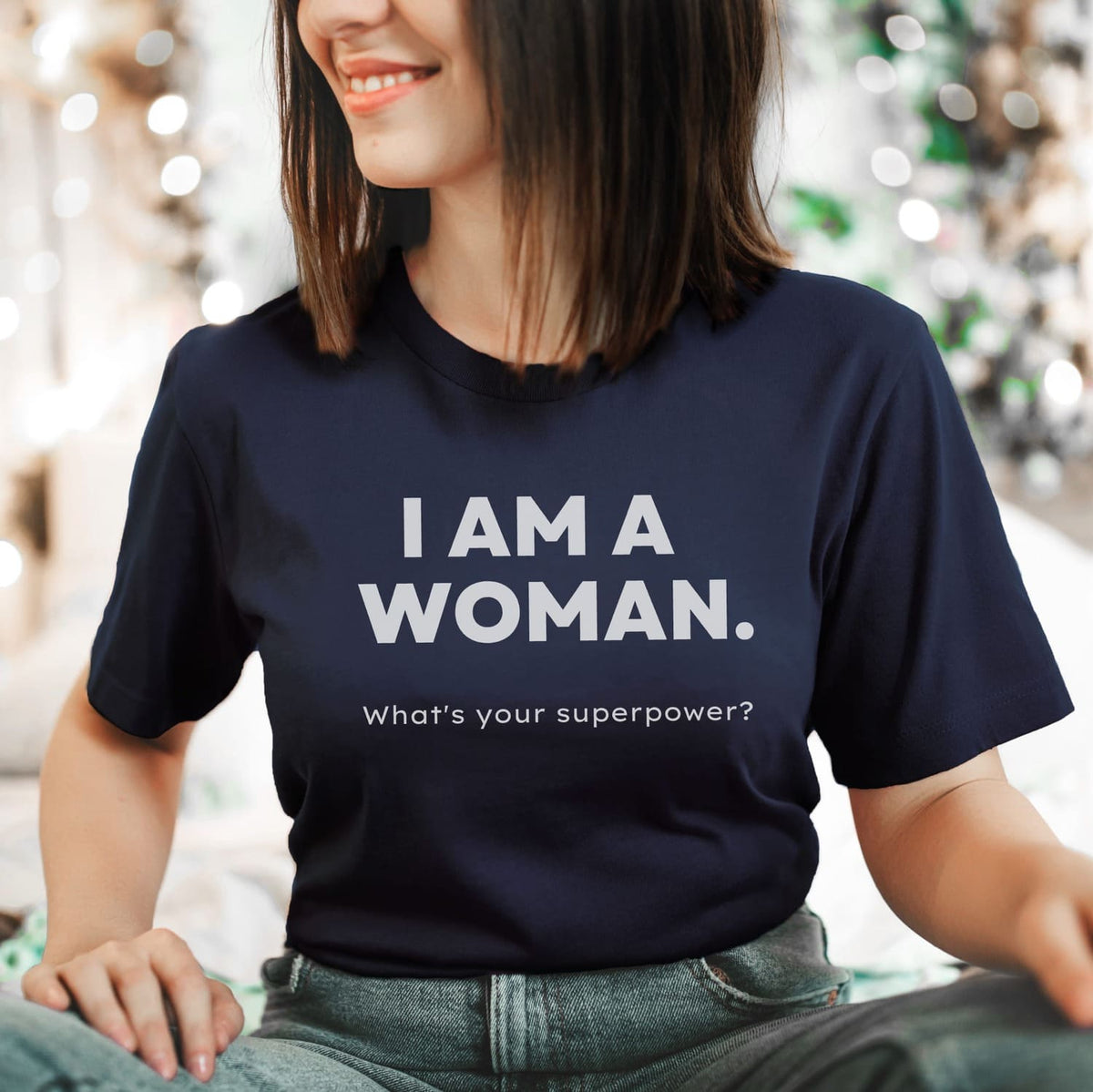 Person wearing a blue feminist t-shirt with 'I AM A WOMAN. What's your superpower?' text.